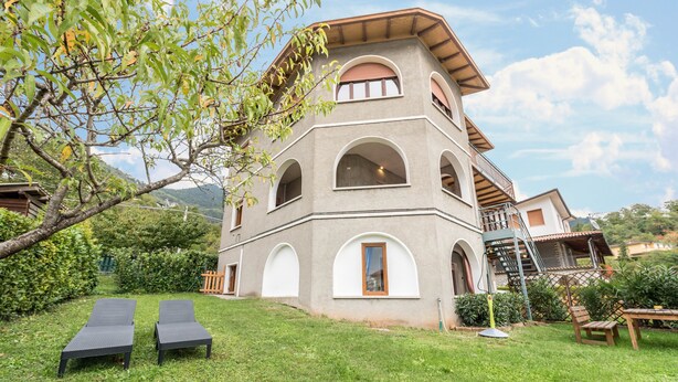 Un bâtiment à deux étages, doté d’un toit en pente, de nombreuses fenêtres en arc de cercle et d’un balcon.