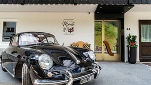 Een klassieke zwarte cabrio geparkeerd voor een hotel genaamd 'Monte M4'.