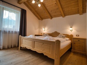 Ein hölzernes Bett mit Kopfteil, zwei Nachttische und ein Beistelltisch.