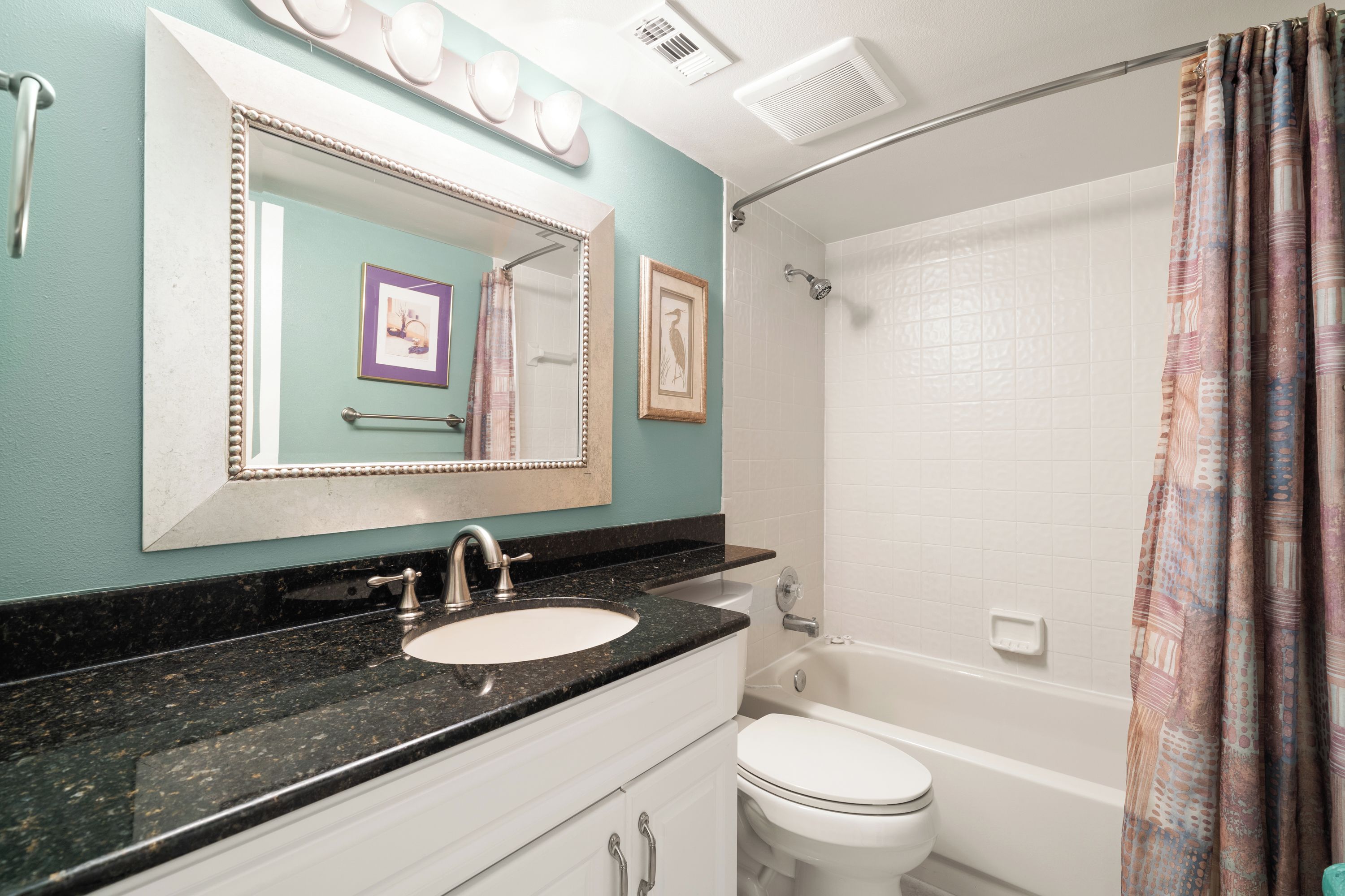 A bathroom with a sink, mirror, and toilet.