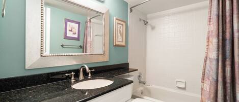 A bathroom with a sink, mirror, and toilet.