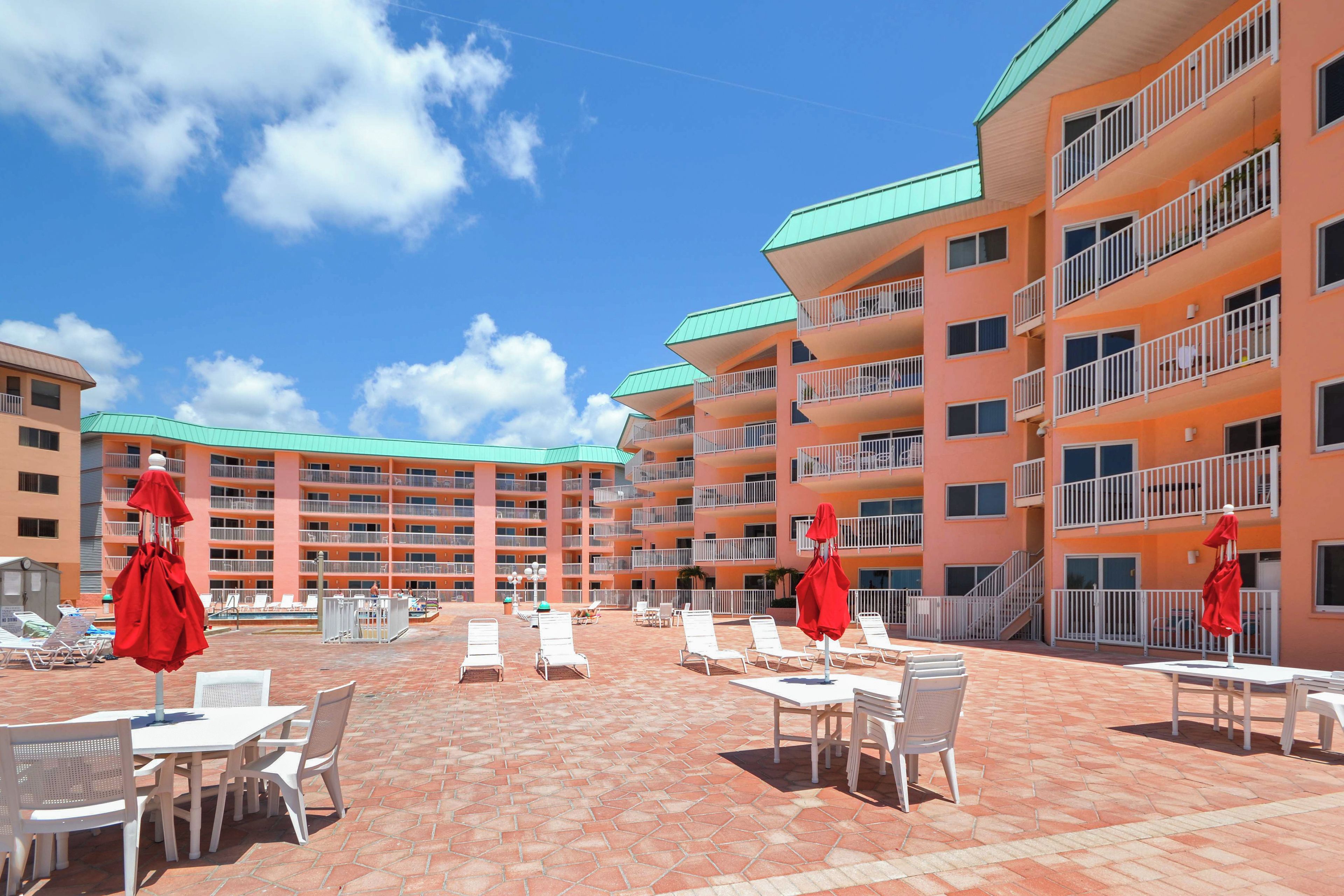 A hotel courtyard with outdoor seating and a pool area.