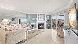 Una sala de estar con chimenea, un sofá, una mesa de centro y un televisor.