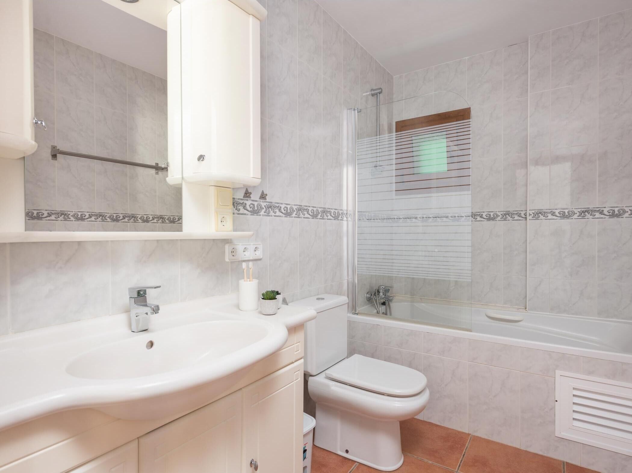 A bathroom with a sink, toilet, and shower.