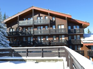 Ein mehrgeschossiges Holzgebäude mit Balkonen, vermutlich ein Hotel oder eine Lodge.