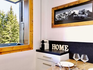 Eine moderne Küche mit Bergblick, einem gerahmten Foto an der Wand und einem Schild mit der Aufschrift 'HOME' auf der Arbeitsfläche.