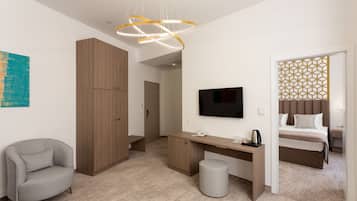 Una habitación de hotel moderna con un armario de madera, un escritorio con televisor de pantalla plana, una silla, una cama y un panel decorativo en la pared.