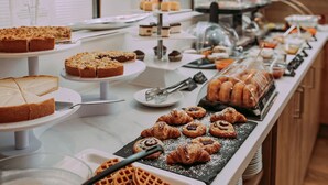 Un buffet proposant une variété de desserts, comme des gâteaux, des pâtisseries et des gaufres.