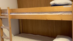 A bunk bed with a wooden headboard and a ladder.