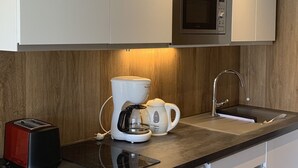 A modern kitchen with a microwave, coffee maker, and toaster.