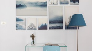 Una habitación con un escritorio de vidrio, una silla azul y una lámpara.