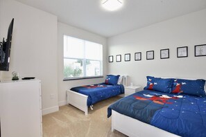 Une chambre avec deux lits, une fenêtre et une commode blanche.