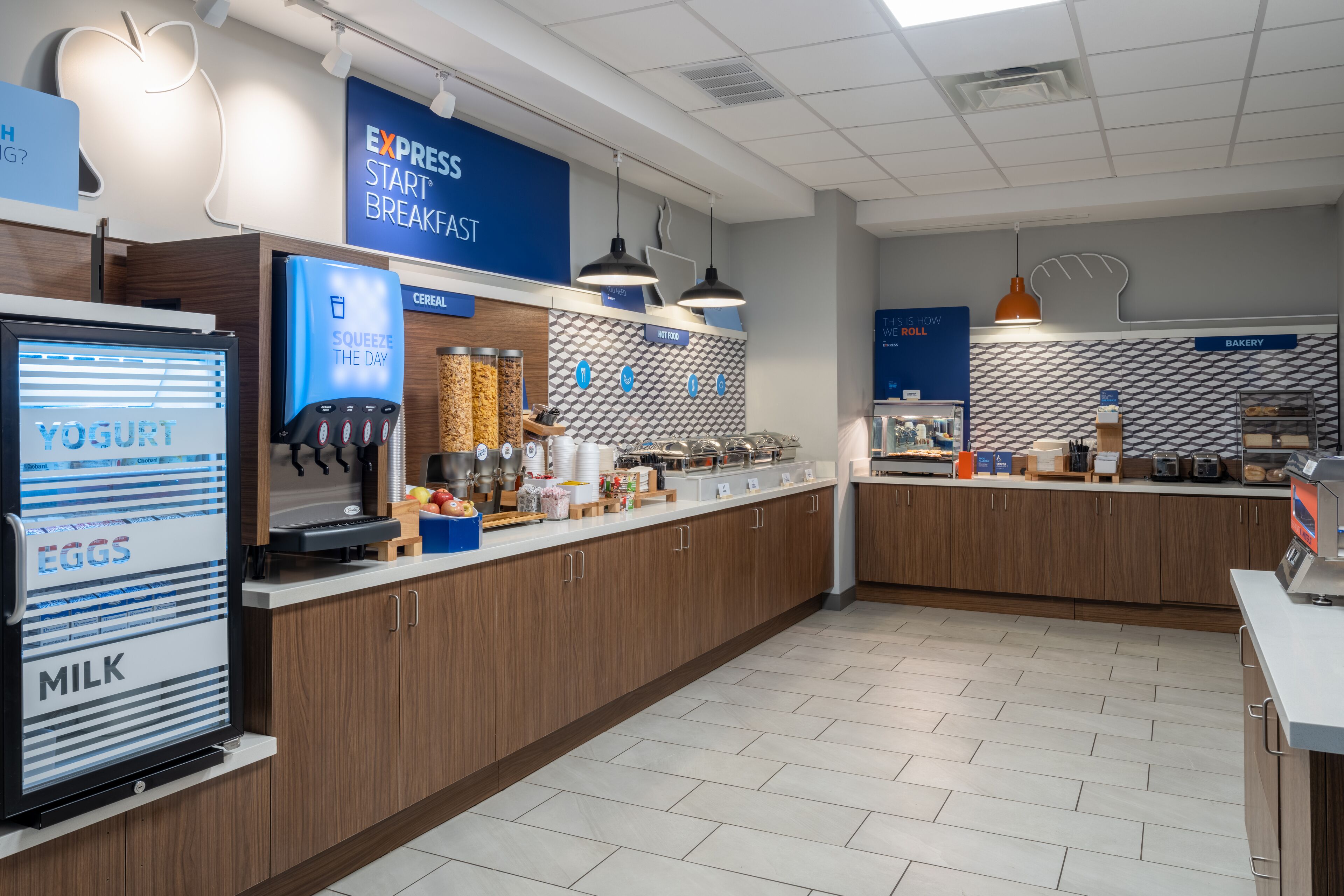 A modern breakfast area with a yogurt machine, cereal dispenser, and a bakery section.