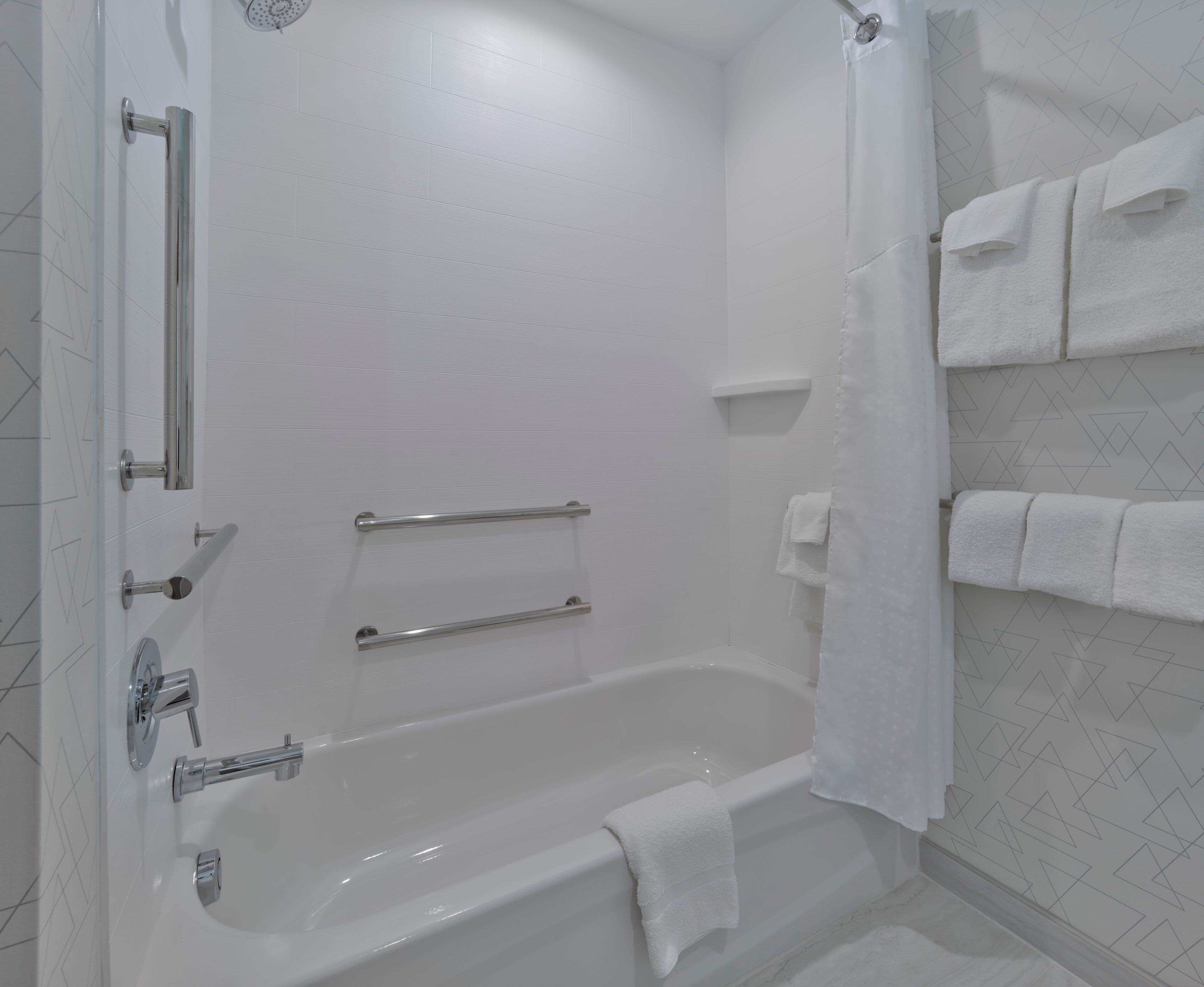 Une salle de bain moderne équipée d’une baignoire, d’une douche et de toilettes.