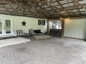 A covered outdoor area with a gravel floor, a bench, a table, and a star decoration on the wall.
