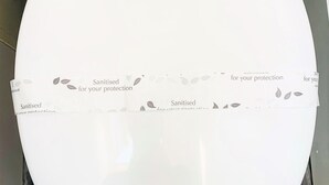 A white toilet with a paper strip across the seat and lid, stating "Sanitised for your protection." - Swansea Beach Townhouse (Swansea)