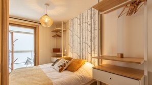 Makuuhuoneessa on sänky, yöpöydät, vaatekaappi ja ikkunasta avautuu näkymä ulkona olevalle parvekkeelle.