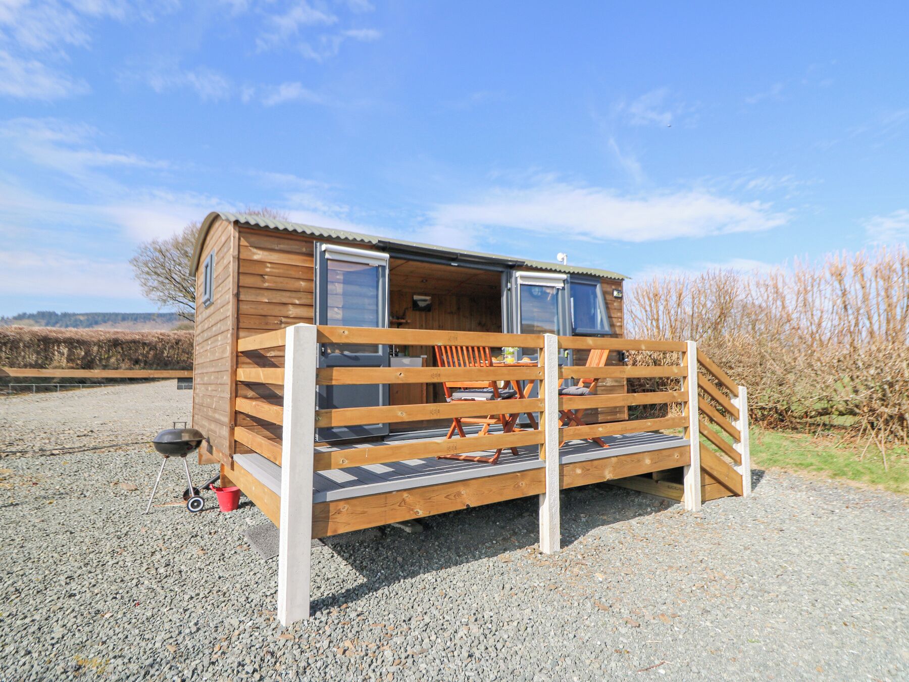 A small wooden cabin with a deck and a sliding door.