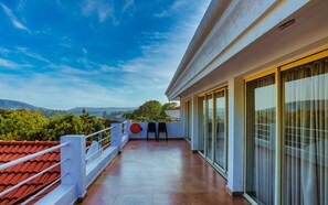 A balcony with a view of the landscape, a railing, and a door with glass panels. - Casa Ahaana Resort Vagator, by Lavin Hotels (Vagator)