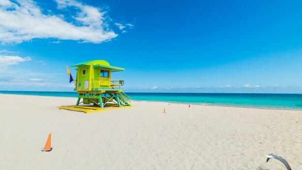 Une tour de surveillance des sauveteurs sur une plage, sous un ciel dégagé.
