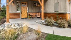 Eine Holzjagdhaus mit Veranda, einer Willkommensschild und zwei Adirondack-Stühlen.