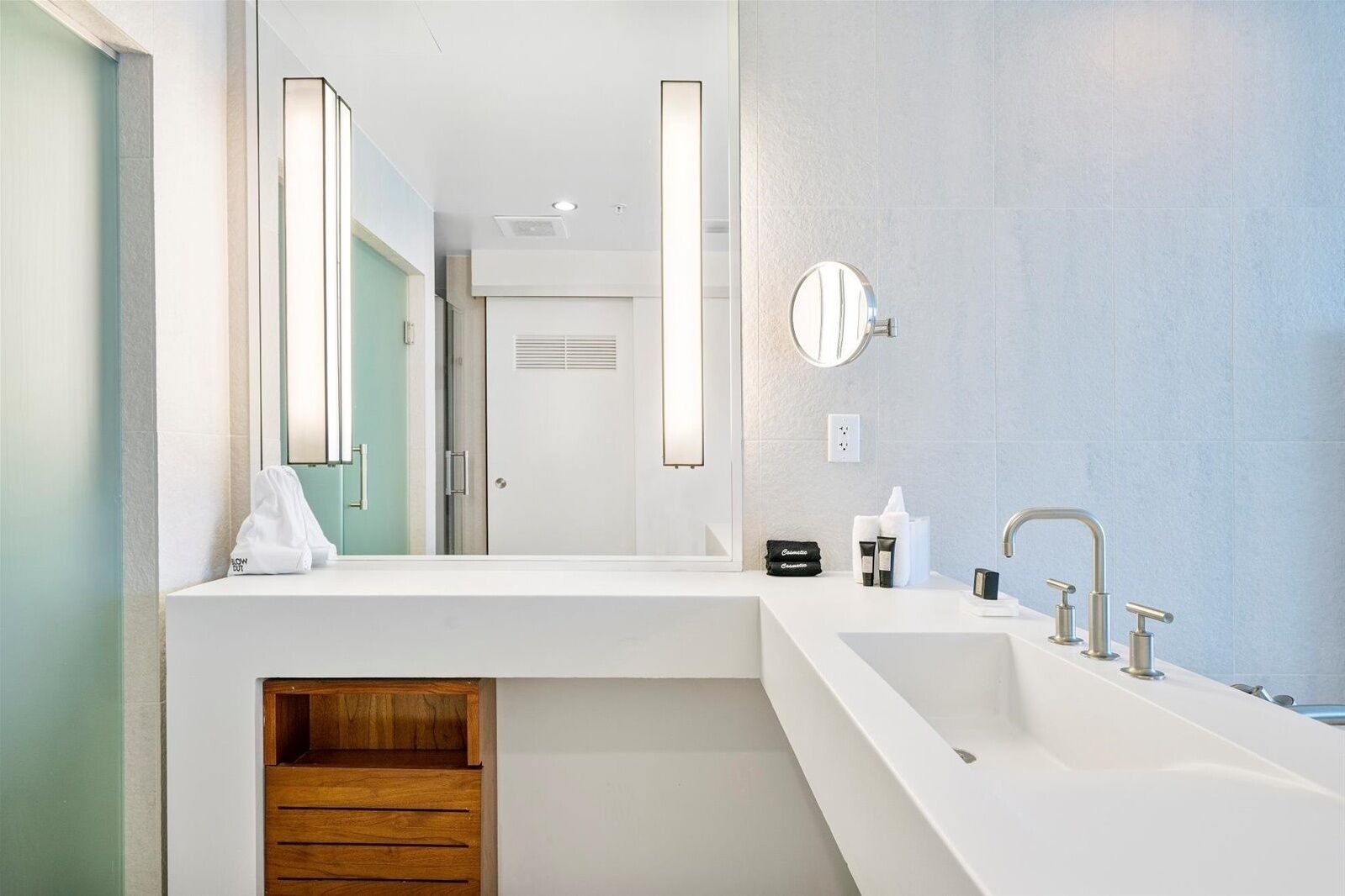 Une salle de bain moderne avec un grand lavabo blanc, un miroir et un meuble-lavabo en bois.