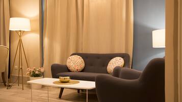 A modern living room with a sofa, two armchairs, a coffee table, and a floor lamp.