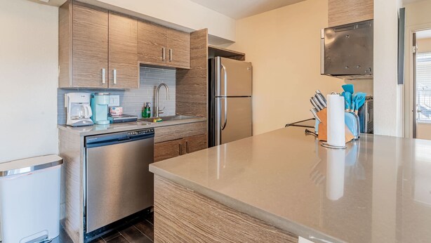 Una cocina moderna con armarios de madera, electrodomésticos de acero inoxidable y lavavajillas.