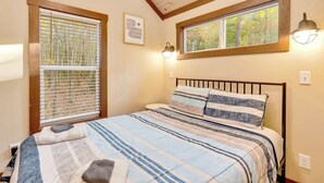 A bedroom with a bed, two windows, and a ceiling with wooden beams. - Serene, Hiking, Dreamer at Mentone Free Internet! (Mentone)