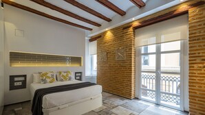 Een slaapkamer met een bed, een raam met uitzicht en een bakstenen muur.
