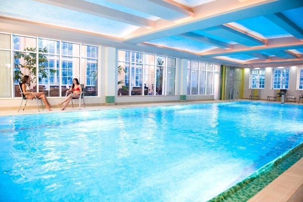 Una piscina techada, sillones reclinables de piscina