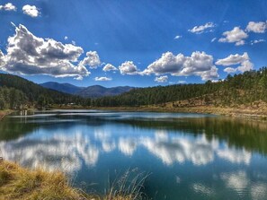 A serene lake surrounded by mountains and trees. - Elks Landing by Ruidoso Vacation Rentals (Ruidoso)