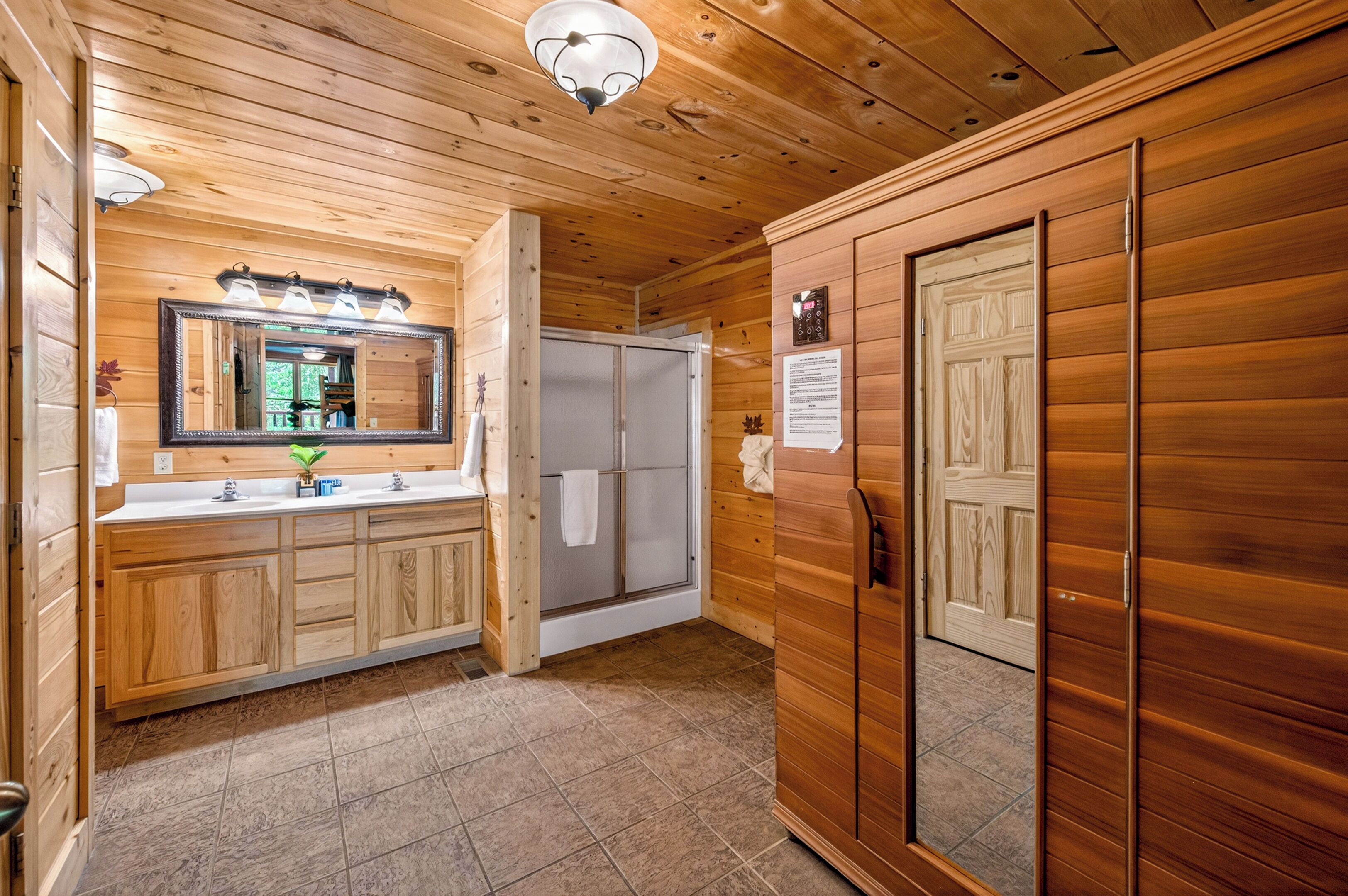 A wooden interior with a bathroom, including a sink, mirror, and shower.