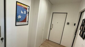 A hallway with white doors and a framed poster on the wall. - PONENTINO 🍾2 Luxury apartments (Trieste)