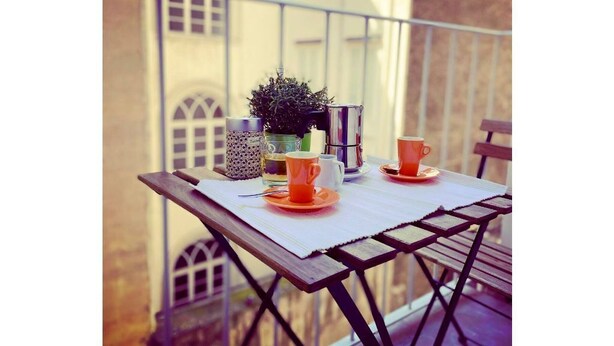 A balcony table with a potted plant, two orange cups, and a glass. - NEVERIN 🍾3 Luxury apartments (Trieste)