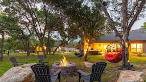 An outdoor seating area with chairs, a fire pit, and a hanging chair.