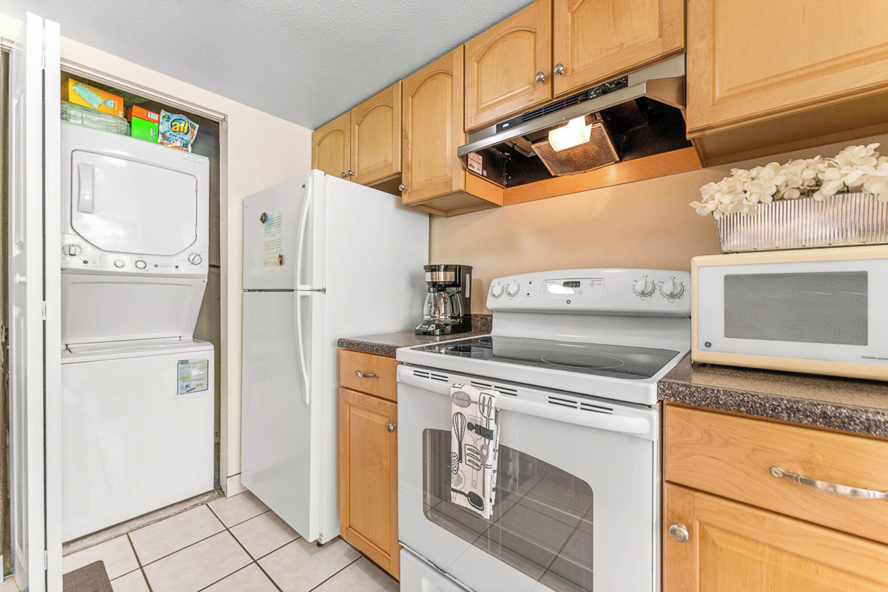 A kitchen with wooden cabinets, a white refrigerator, a stove, and a microwave.