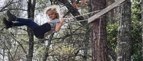 A person on a wooden platform in a forested area.