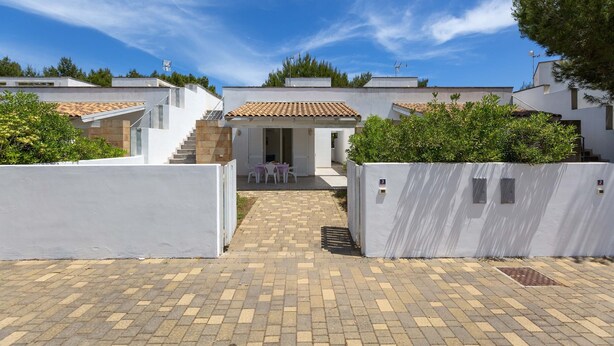 A courtyard with a paved walkway leading to a small seating area with tables and chairs. - Villette Girovagando - Superior by BarbarHouse (Torre dell'Orso)
