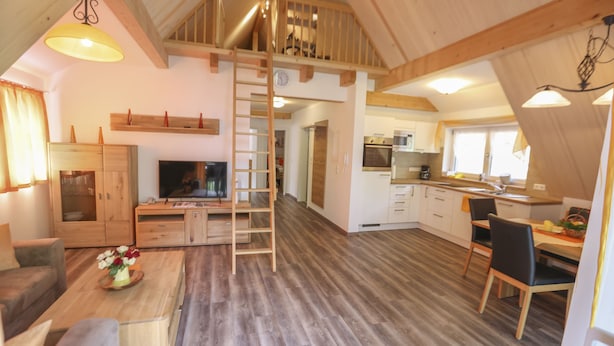 A spacious loft-style living area with a loft bed, wooden floors, a dining area, and a kitchen. - Vacation apartment Sonnenblick (Zell am Harmersbach)