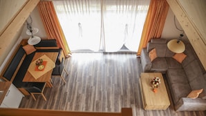 A modern interior with a dining area, sofa, and a wooden coffee table. - Vacation apartment Sonnenblick (Zell am Harmersbach)