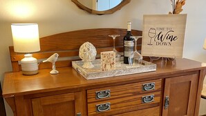 A wooden dresser with drawers, a mirror, a lamp, a wine bottle, and a decorative sign. - Killington Sun Dog Trail ski-on ski-off 2 bedroom 2 bathroom 1st floor condo (Killington)