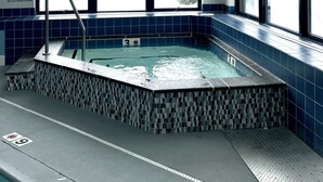 A hot tub with a view of a snowy landscape through large windows. - Killington Sun Dog Trail ski-on ski-off 2 bedroom 2 bathroom 1st floor condo (Killington)