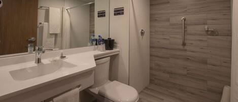 Un bagno moderno con lavandino, WC e zona doccia, tutto in bianco.