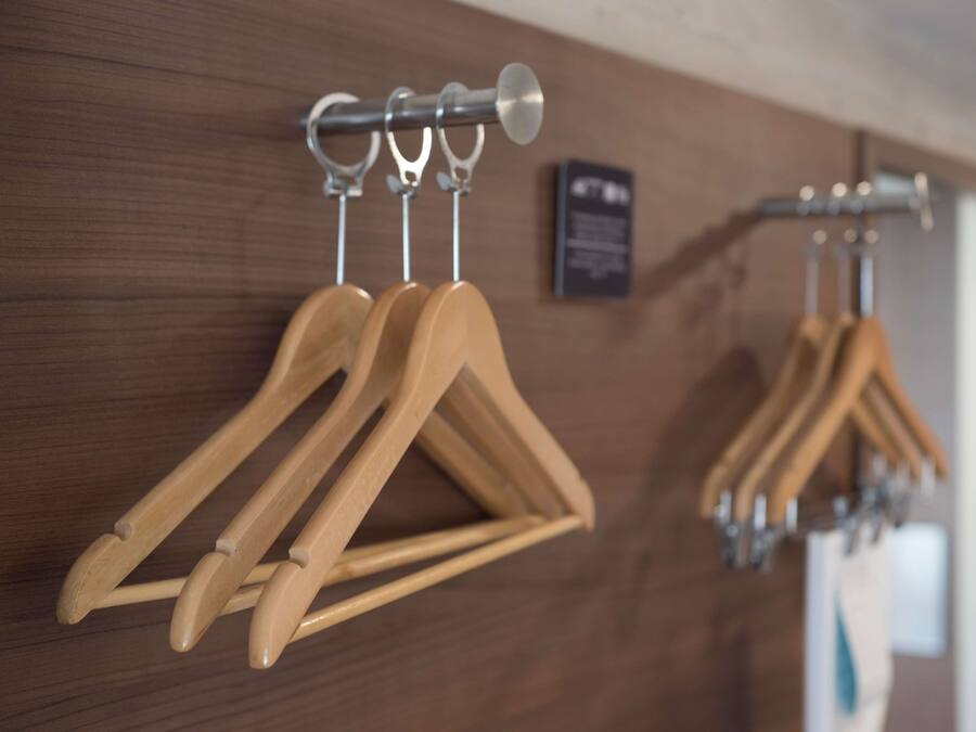 Wooden coat hooks on a wall with a plaque.