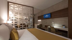 A hotel room with a bed, a desk, and a TV mounted on the wall. - Microtel Inn & Suites by Wyndham Guadalajara Sur (Tlajomulco de Zúñiga)