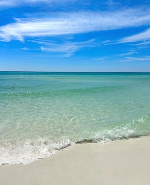 A beach with clear turquoise water and a sandy shore.