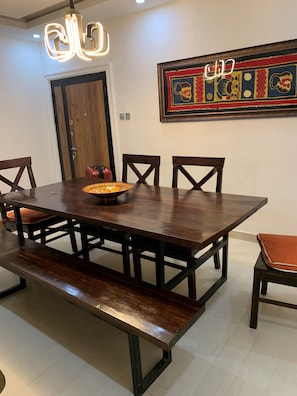 Un espace repas avec une table en bois, des bancs et des chaises.