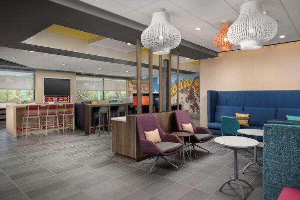 A modern lounge area with seating, a counter, and a mural on the wall. - Tru by Hilton San Antonio North (San Antonio)