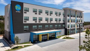 A modern hotel building with a flat roof, multiple windows, and a blue and gray color scheme. - Tru by Hilton San Antonio North (San Antonio)